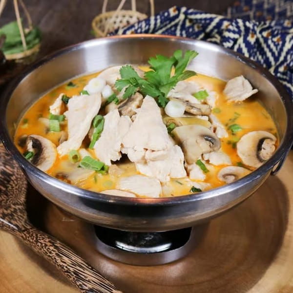 Thai E-San's Tom Kha Gai soup, with chicken, mushrooms, and cilantro in a metal bowl.